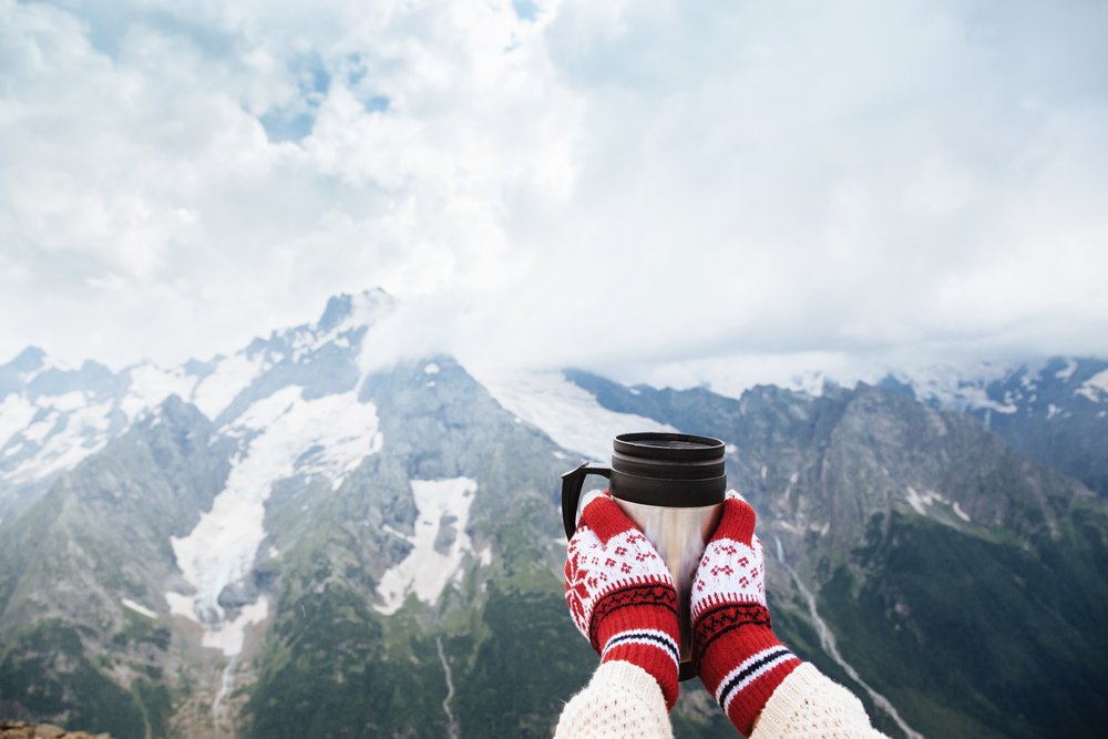 Closeup,Photo,Of,Thermos,Mug,With,Tea,In,Traveler's,Hand